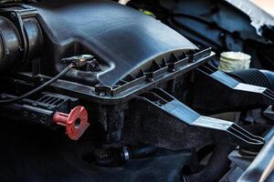 Closeup of a car engine air intake system. Automobile engine compartment with air filter housing. Vehicle maintenance, auto parts, engineering and transportation technology concept photo