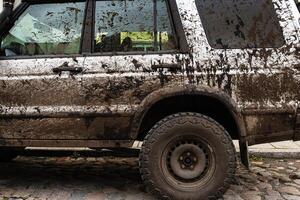 Dirty 4x4 vehicle with mud splatters on body, windows, wheels, tires. Dirty offroad suv car covered in dirt. Rugged terrain adventure, extreme driving, four wheel drive challenges 4 photo