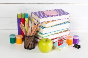 Set of school supplies on white table, front view photo