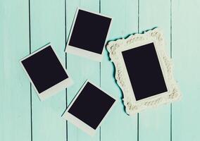 Collection of empty picture frames and polaroids on a light blue wooden background in a creative workspace photo