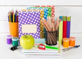 Set of school supplies on white table, front view photo