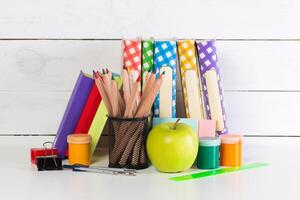 Set of school supplies on white table, front view photo