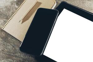 Close up of smartphone with notepad and drink on grunge wooden background photo