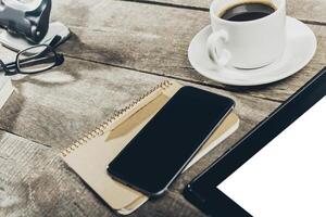 Close up of smartphone with notepad and drink on grunge wooden background photo
