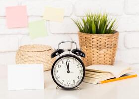 Reminder note and black old-fashioned alarm clock photo