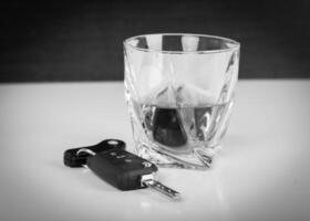 Glass with cognac or whiskey and car keys on table photo