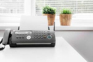 Black fax machine tool close up, business concept photo