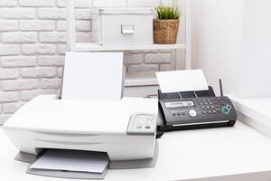 Printer and fax machine on office table photo