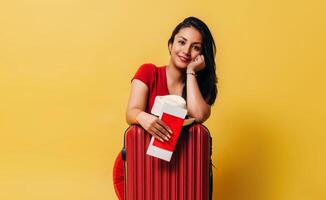 hispanic woman with suitcase and passport. concept of travel. photo