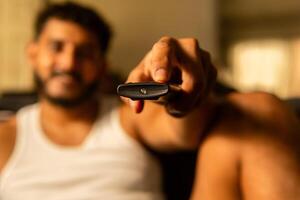 Man using remote control, changing channels on smart tv, streaming apps and shows photo