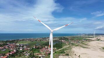 Wind power tower seen from behind and the ocean in the background with a blue sky video