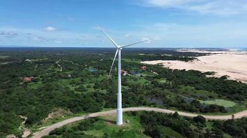 Wind power tower seen the middle of trees with a path and dunes video