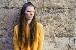A cheerful and colorful youthful expression captured against a rough textured wall backdrop photo