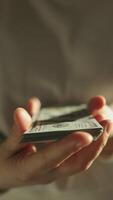 A woman sits near a heater, counting dollar bills with worry. Rising utility bills and prices create stress as the energy crisis unfolds. Decisions about finances weigh heavily. video