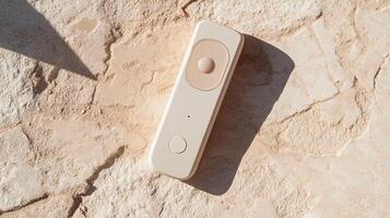 A white remote control laying on a stone surface photo