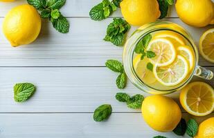 Lemonade in a Glass Pitcher with Lemons and Mint on Wooden Background photo