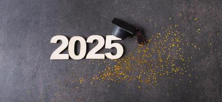 Black graduation cap with 2025 number on dark background with tinsel photo