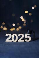Graduation cap on wooden number 2025 on dark background with bokeh. Class of 2025 concept. photo