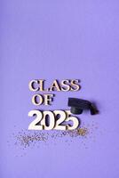 Class of 2025 text and graduation cap on purple background photo