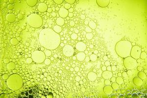 Abstract composition with water and oil drops against green background photo