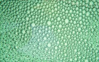 Texture of soap bubbles and water with green light photo
