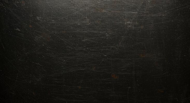 A black metal plate with scratches and scratches