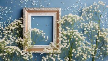 Frame on blue wall with white flowers photo