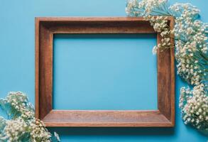 Wooden frame with flowers on blue background photo