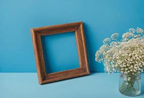 Wooden frame with baby's breath on blue background photo