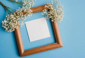 Blank white paper in wooden frame on blue background photo