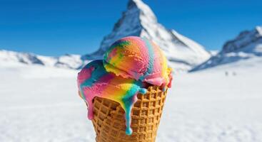 A cone of ice cream with rainbow colored ice cream on top of a mountain photo