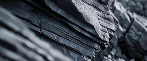 Dark grey and black rock face showing texture and strata. photo