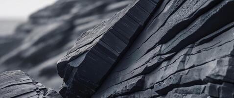 Dark grey and black rock face showing texture and strata photo