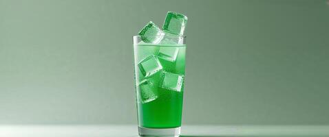 Refreshing Green Beverage with Ice Cubes in a Clear Glass on a Soft Green Background. photo