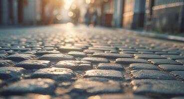 Warm sunlight illuminates cobblestone street creating a charming and rustic urban setting. photo