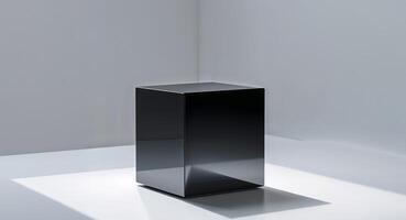 A glossy black cube sits on a light background exhibiting its geometric shape and shadows. photo