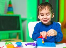 Child plays with bright toys. A young boy enjoys playing with a bright toy set, showing joy and concentration during a creative activity at home. photo