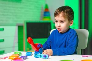 Boy enjoys creative playtime. A young boy plays enthusiastically with colorful toys, expressing joy and curiosity in an inviting space. photo