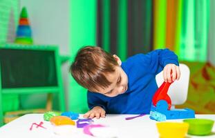Child engaged in creative play indoors. A young child is playing with colorful educational toys at a table in a bright indoor space. photo