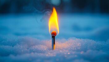 Match ignited in snow during twilight. A single match burns brightly, surrounded by fresh snow under a dusky sky at twilight, creating a serene atmosphere. photo