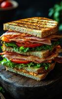Layered meat and veggie sandwich. A hearty sandwich stacked high with lettuce, tomatoes, and meats between toasted bread, ready to enjoy photo