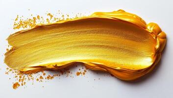 Golden paint spread on a white surface. A vibrant golden paint is smeared across a clean white canvas, creating an elegant and glossy finish that shines. photo