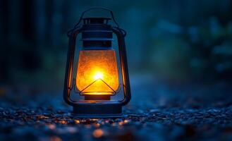 A lantern is lit up in the dark, creating a warm and cozy atmosphere. The lantern is placed on a rocky ground, surrounded by leaves and twigs. Concept of calm and relaxation photo