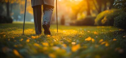 A person is walking in a park with a cane. The grass is green and the leaves are yellow photo