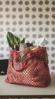 Full shopping bag on table on wall background photo