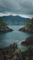 A view of the ocean and mountains from a rocky shore photo