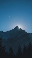 A full moon over a mountain range photo