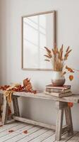 Mockup of a wooden bench with autumn leaves and a picture frame in a white room with photo