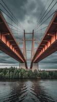 A bridge spanning over a river with dark clouds photo