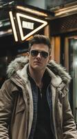 A man in sunglasses and a coat standing in front of a building photo